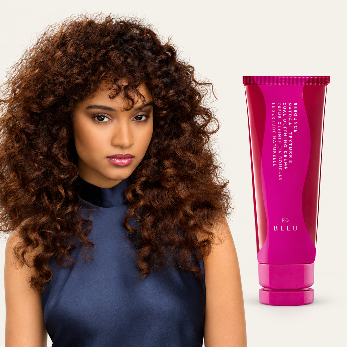 R+Co Bleu Rebounce Natural Texture and Curl Defining Creme 148 ml, tubka z różową etykietą obok modelki z kręconymi włosami | Ellemania