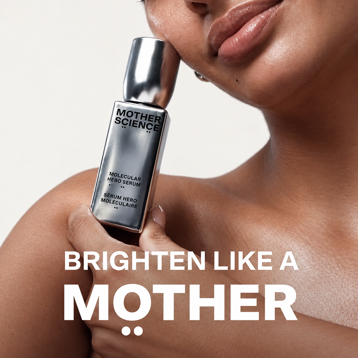 Mother Science Molecular Hero Serum - modelka trzyma srebrną butelkę przy brodzie, na dole napis Brighten like a Mother | Ellemania