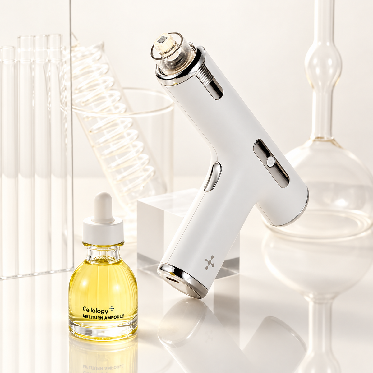 Cellology Meliturn Shot Gun & Ampoule 2.0 Set - białe urządzenie z końcówką i szklana ampułka z żółtym płynem wśród szkła laboratoryjnego | Ellemania