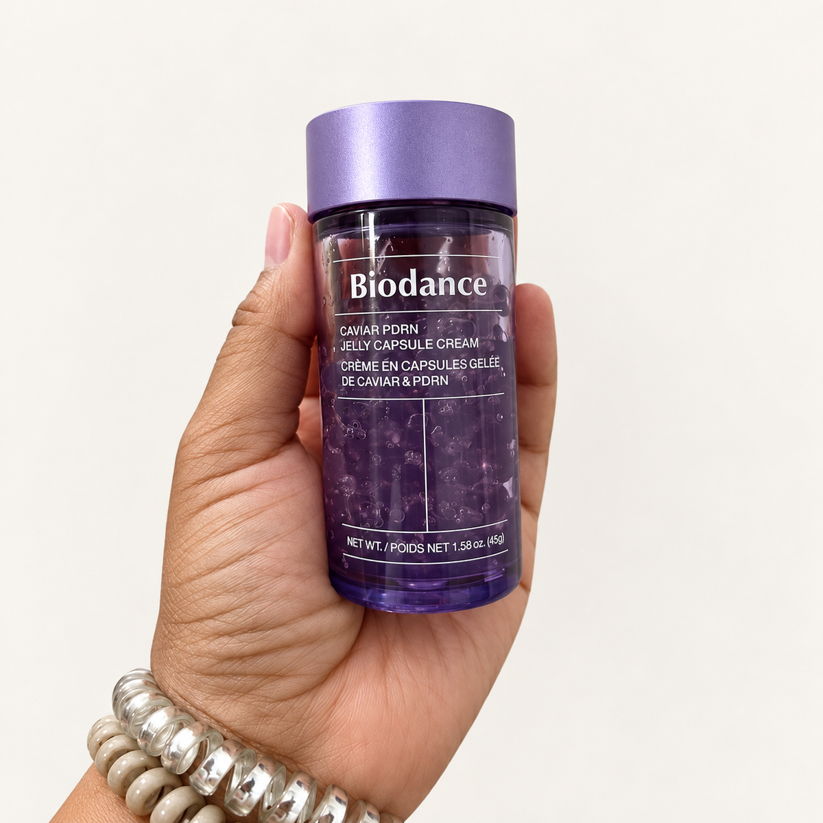 Biodance Rejuvenating Caviar PDRN Capsule Cream - dłoń trzyma fioletowy słoik z kapsułkami | Ellemania