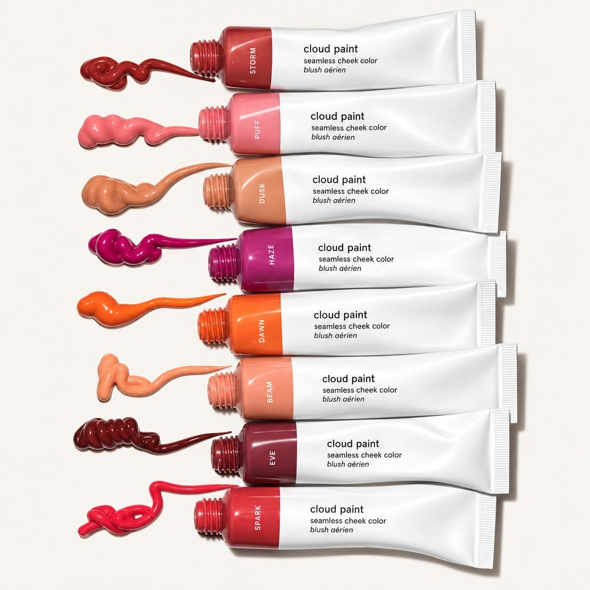 Glossier Cloud Paint - osiem tubek w odcieniach Storm, Puff, Dusk, Haze, Dawn, Beam, Eve i Spark ułożonych poziomo, obok każdej próbka koloru na jasnym tle | Ellemania