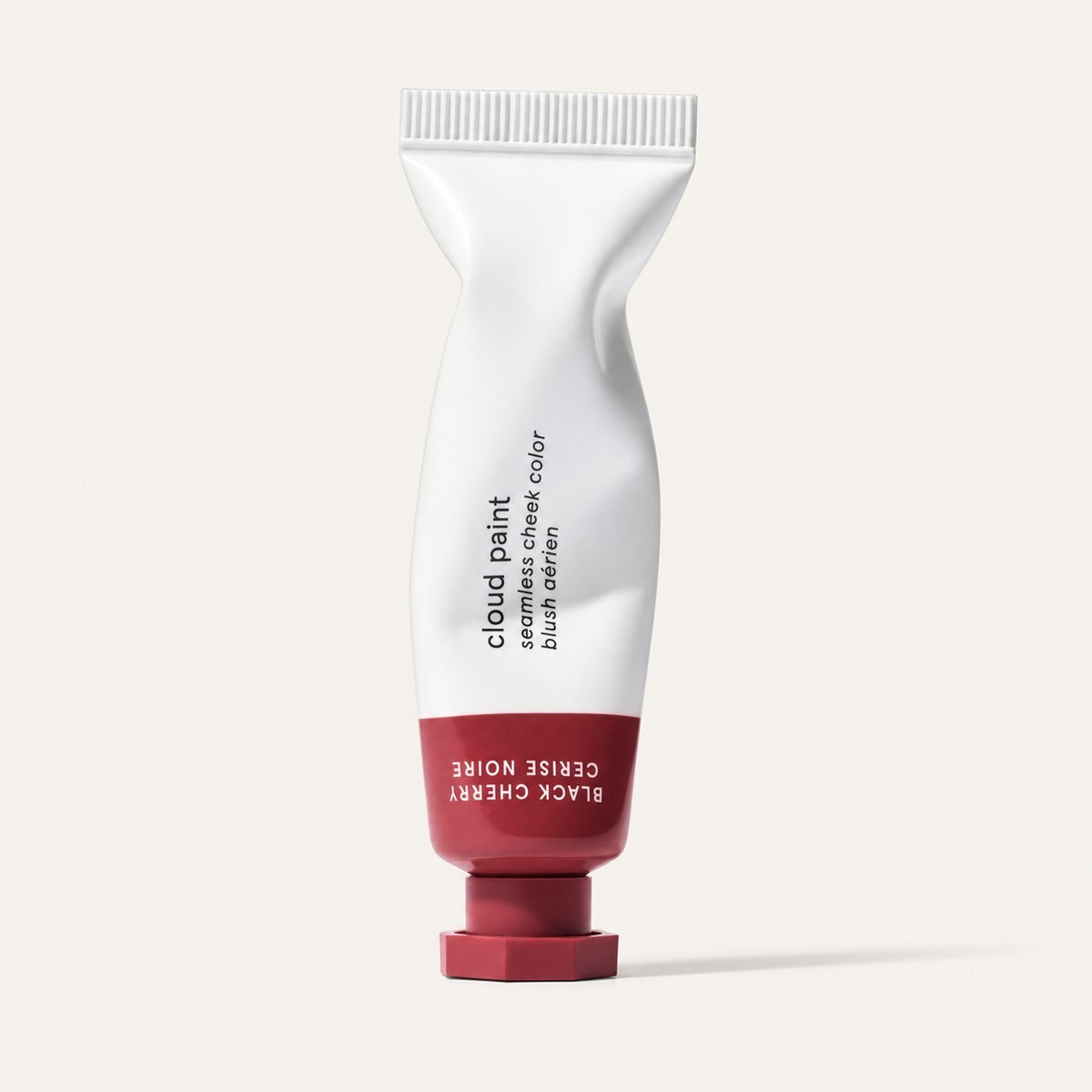 Glossier Cloud Paint - odcień Black Cherry, biała tubka z bordową końcówką i nakrętką, na opakowaniu napis Black Cherry / Cerise Noire, jasne tło | Ellemania