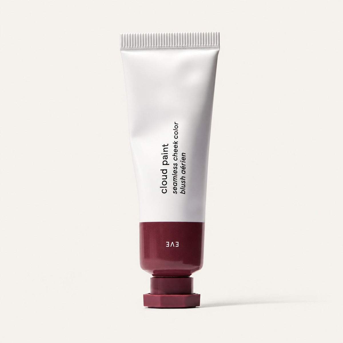Glossier Cloud Paint - odcień Eve, biała tubka z ciemnobordową końcówką i nakrętką, na opakowaniu napis Eve, jasne tło | Ellemania