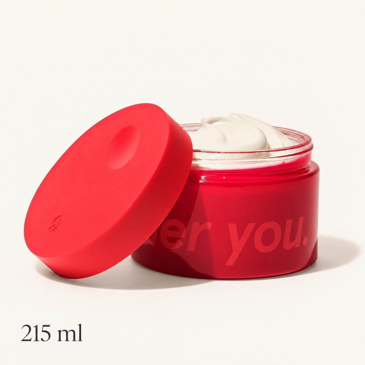 Glossier Crème de You - otwarty czerwony słoik 215 ml z białym kremem i czerwoną nakrętką opartą z boku, napis 215 ml, na jasnym tle | Ellemania
