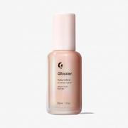 Glossier Futuredew Oil Serum Hybrid 30 ml - brzoskwiniowo-perłowa butelka z jasnoróżową nakrętką i napisem futuredew oil serum hybrid, jasne tło | Ellemania