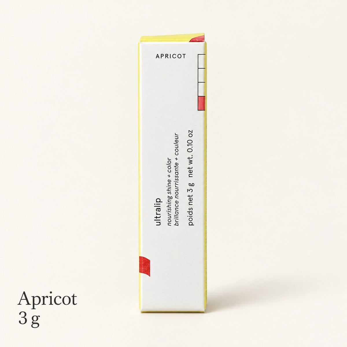 Glossier Limited Edition Ultralip - odcień Apricot, białe pudełko z żółtymi brzegami i napisem APRICOT, 3 g, na jasnym tle | Ellemania