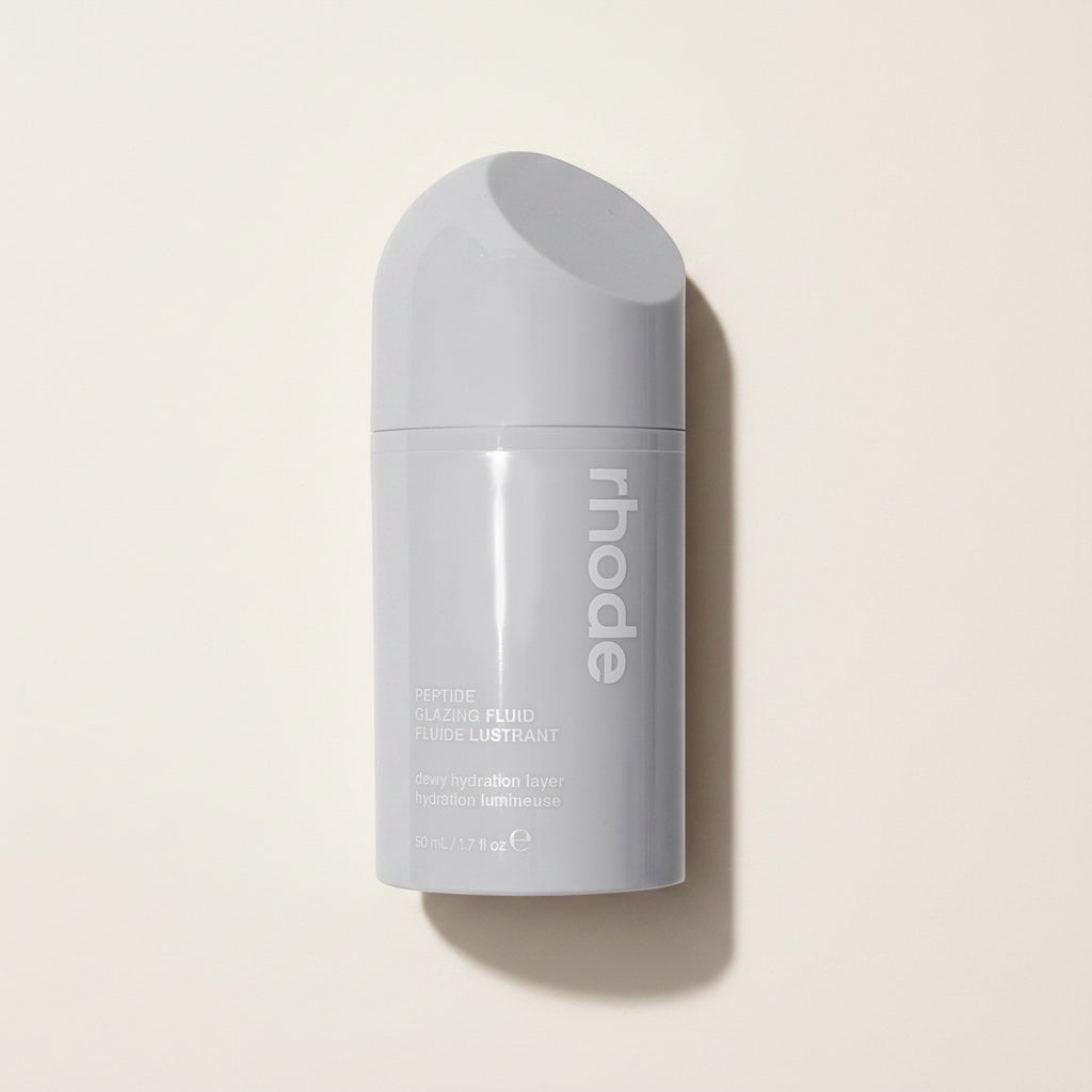 Szare opakowanie serum Rhode Skin Peptide Glazing Fluid z pompką na jasnym tle, produkt do pielęgnacji twarzy ellemania
