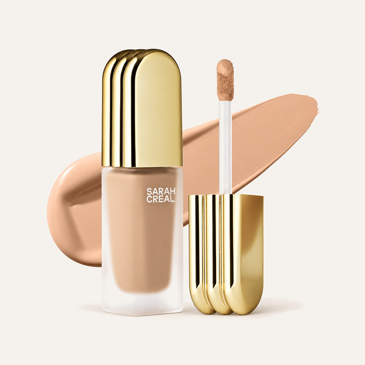 Sarah Creal Face Flex Concealer & Complexion Enhancer 9 ml, gold bottle with applicator next to a concealer swatch | Ellemania