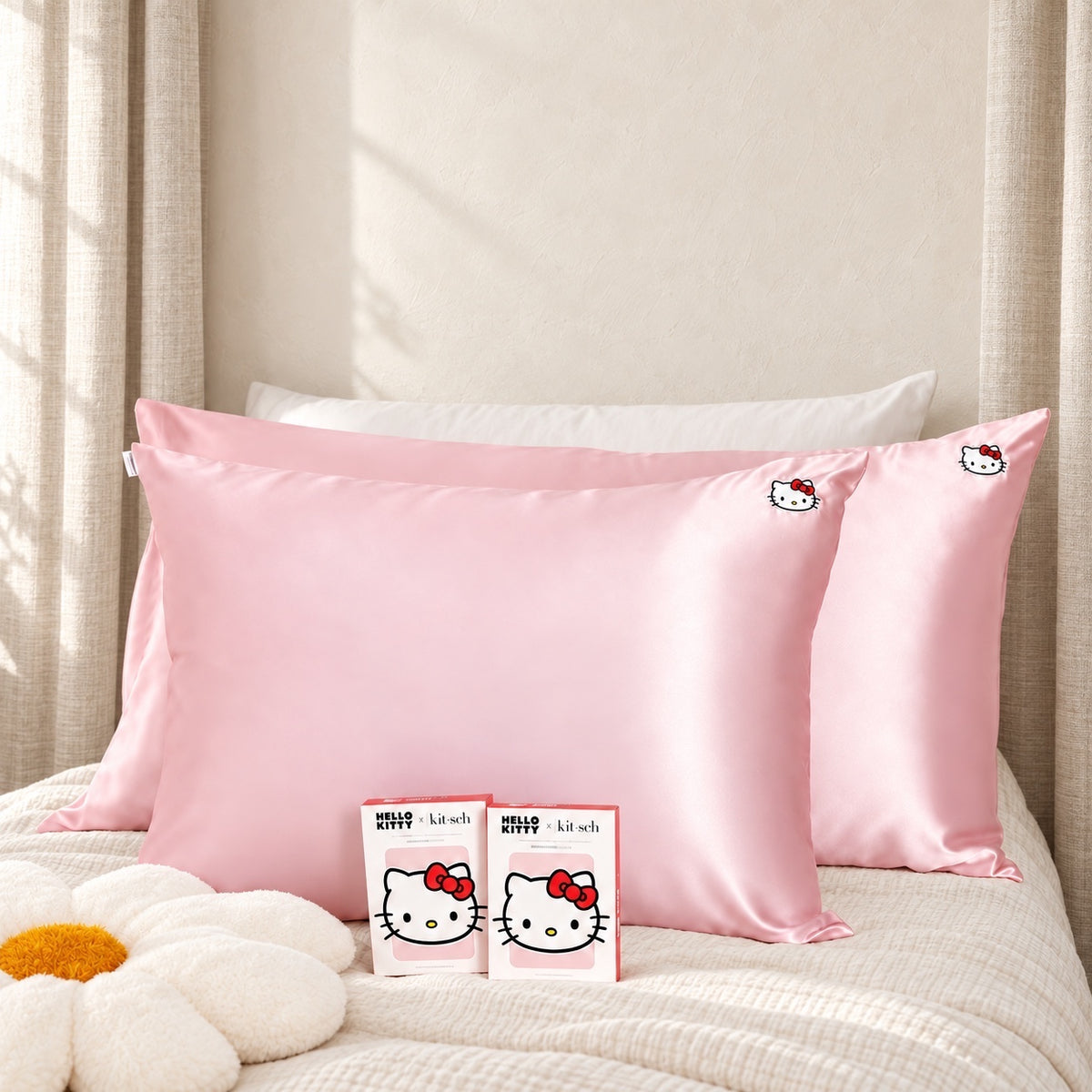 ellemania satynowa poszewka Kitsch x Hello Kitty w kolorze różowym z nadrukiem twarzy Hello Kitty na łóżku
