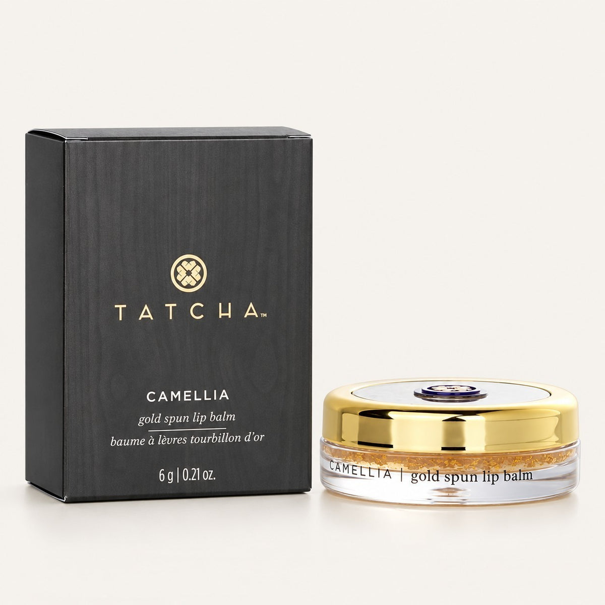 Tatcha Camellia Gold Spun Lip Balm 6 g, pudełko z przodu i balsam w okrągłym słoiczku ze złotą zakrętką | Ellemania