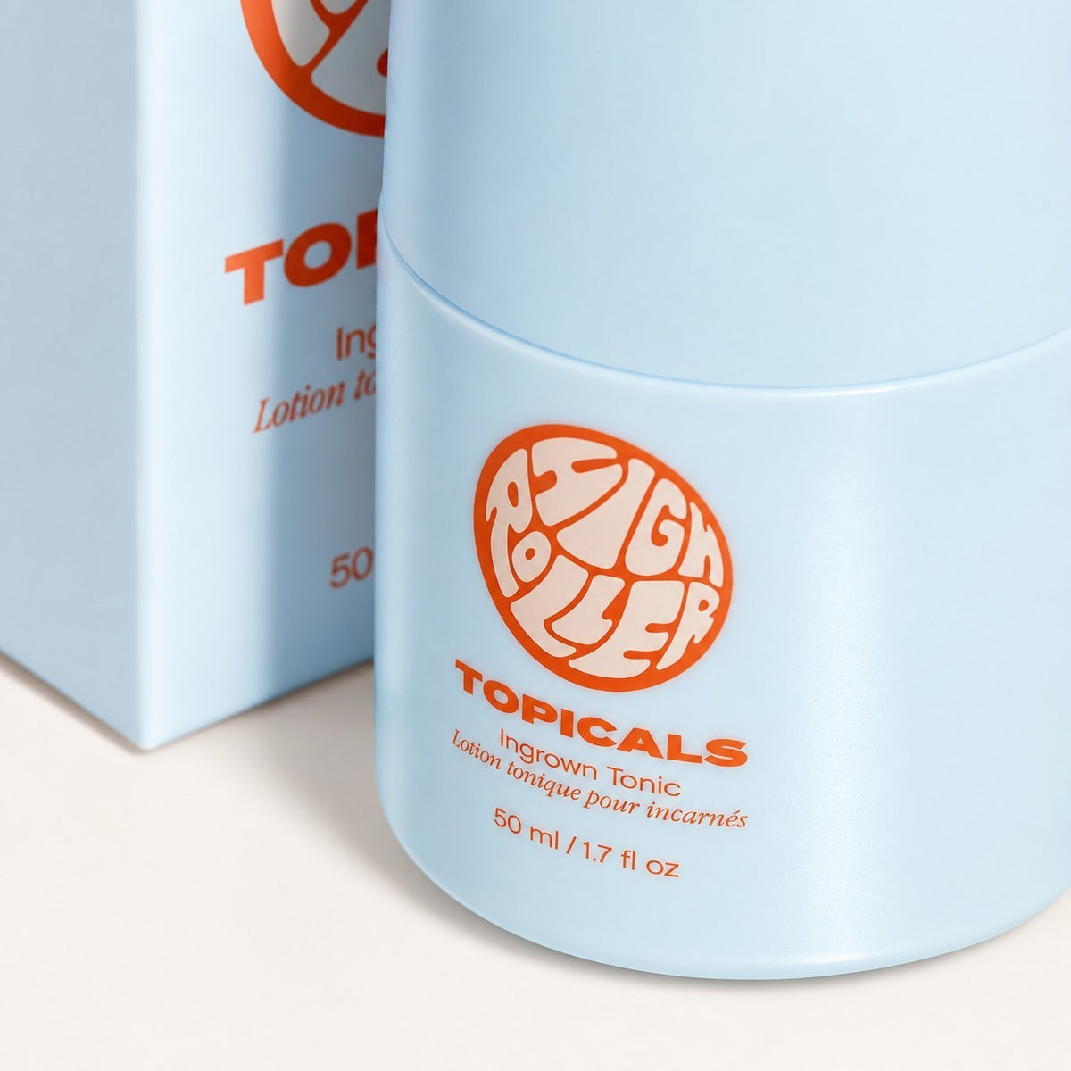 Topicals High Roller Ingrown Tonic - zbliżenie na jasnoniebieską butelkę i pudełko z logo | Ellemania