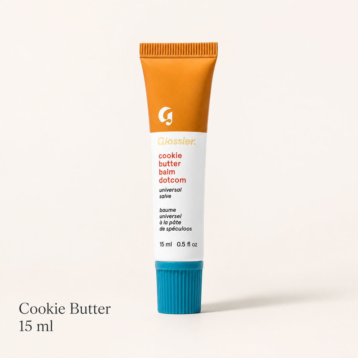 Glossier Balm Dotcom - wariant Cookie Butter, pomarańczowa tubka 15 ml z turkusową nakrętką i napisem cookie butter balm dotcom, na jasnym tle | Ellemania