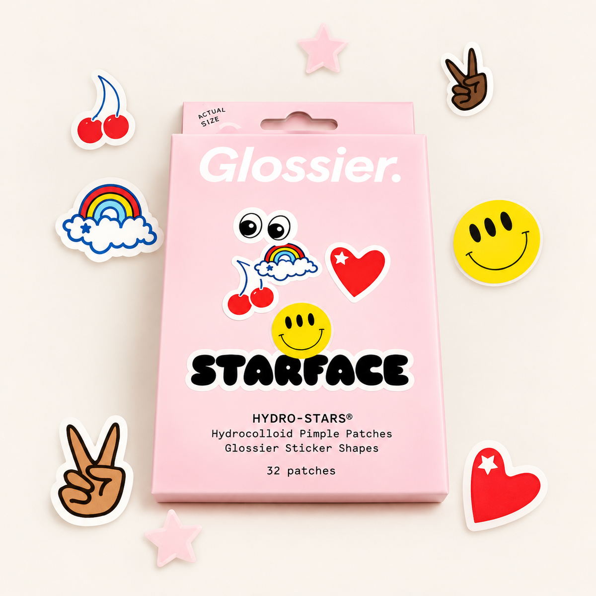 Glossier x Starface Hydro-Stars - różowe pudełko otoczone plastrami w kształcie wiśni, tęczy, uśmiechniętych buziek, serc, gwiazdek i dłoni z gestem pokoju na jasnym tle | Ellemania