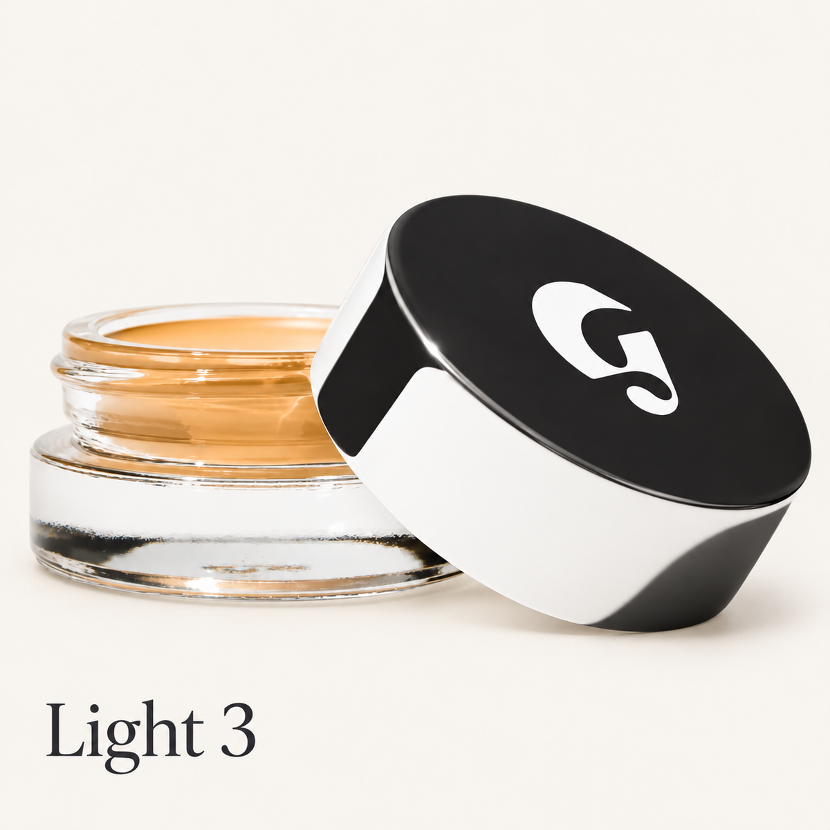 Glossier Stretch Balm Concealer - odcień Light 3, szklany słoiczek ze złocisto-karmelowym korektorem i czarno-białą nakrętką z logo na jasnym tle | Ellemania