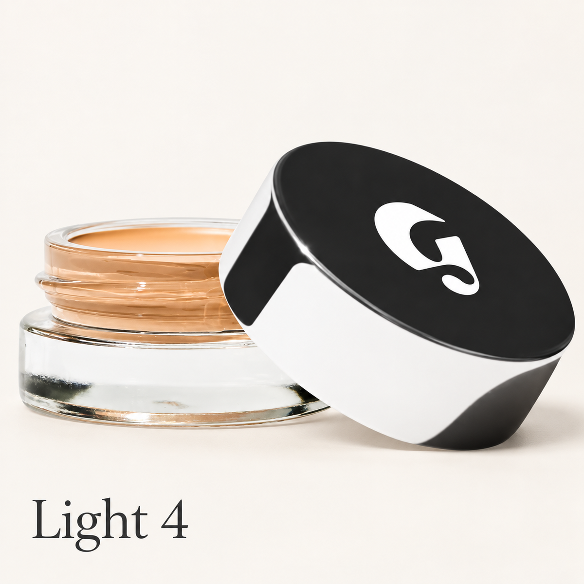 Glossier Stretch Balm Concealer - odcień Light 4, szklany słoiczek z brzoskwiniowo-beżowym korektorem i czarno-białą nakrętką z logo na jasnym tle | Ellemania