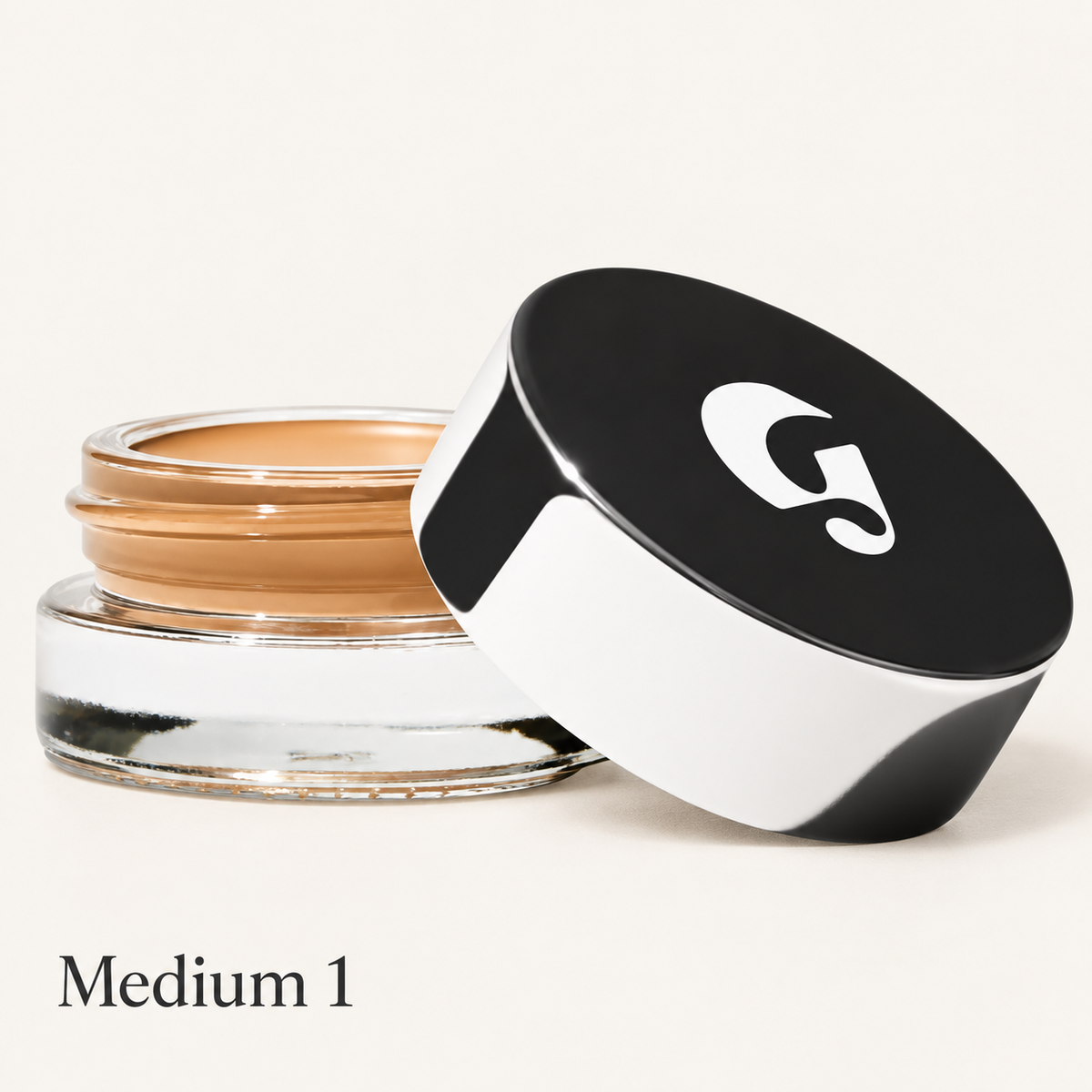 Glossier Stretch Balm Concealer - odcień Medium 1, szklany słoiczek z karmelowym korektorem i czarno-białą nakrętką z logo na jasnym tle | Ellemania