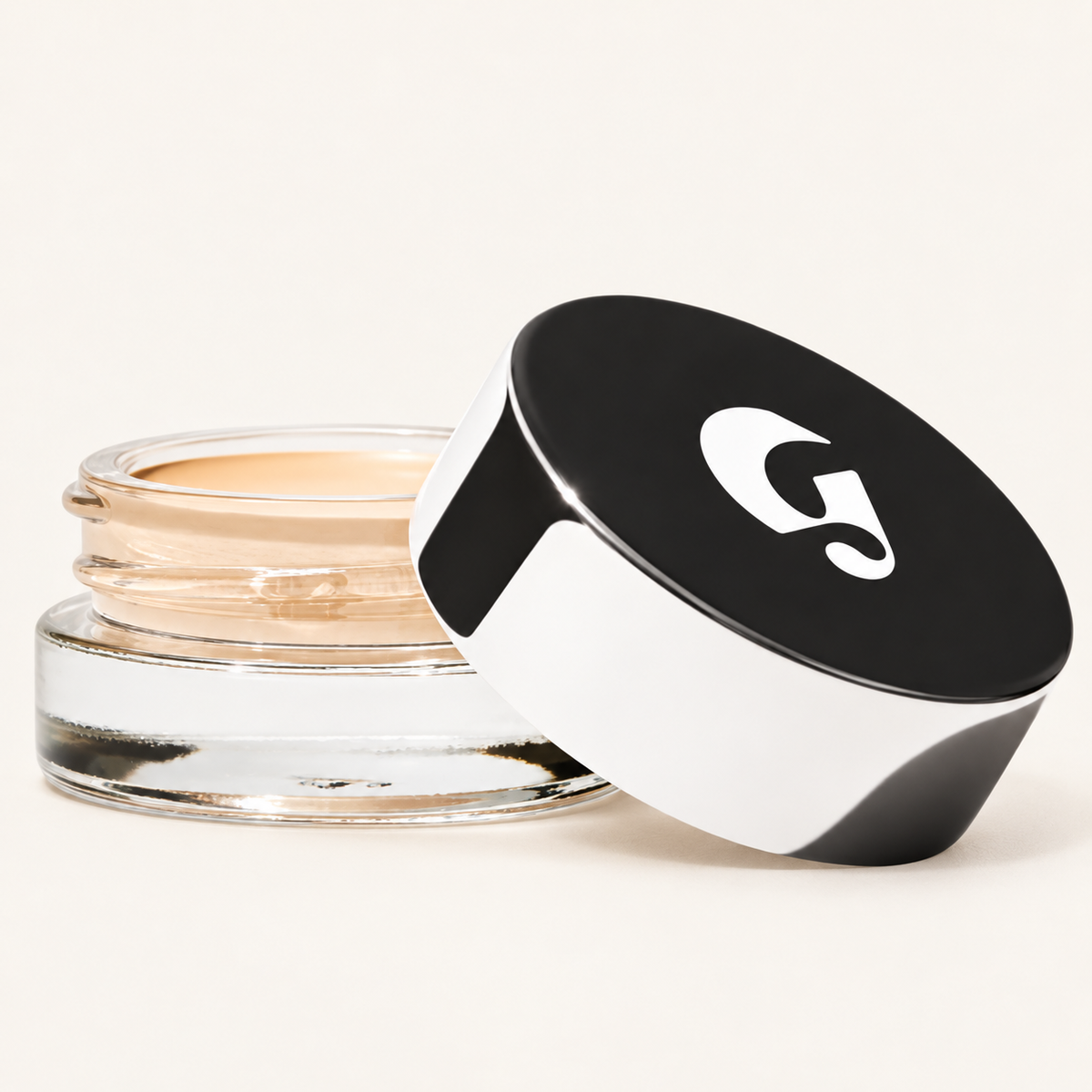 Glossier Stretch Balm Concealer - odcień Very Light 3, szklany słoiczek z jasnym żółtawo-beżowym korektorem i czarno-białą nakrętką z logo na jasnym tle | Ellemania