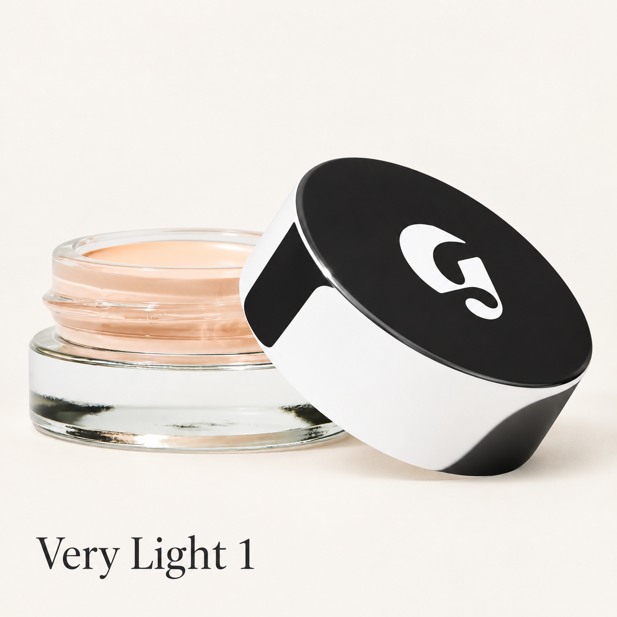 Glossier Stretch Balm Concealer - odcień Very Light 1, szklany słoiczek z bardzo jasnym różowo-beżowym korektorem i czarno-białą nakrętką z logo na jasnym tle | Ellemania