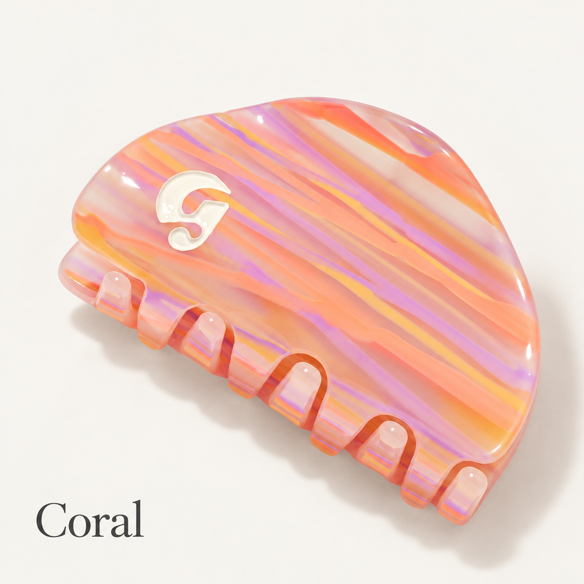 Glossier Claw Clip - spinka do włosów z połyskującymi pasami w odcieniach różu, pomarańczu i fioletu, widok z góry na ząbki i białe logo Glossier, na jasnym tle | Ellemania