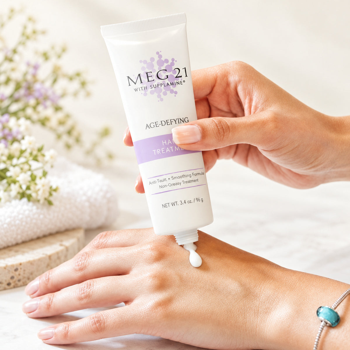 MEG 21 Age Defying Hand Treatment 96 g - dłoń z tubką i kropla kremu na skórze dłoni | Ellemania