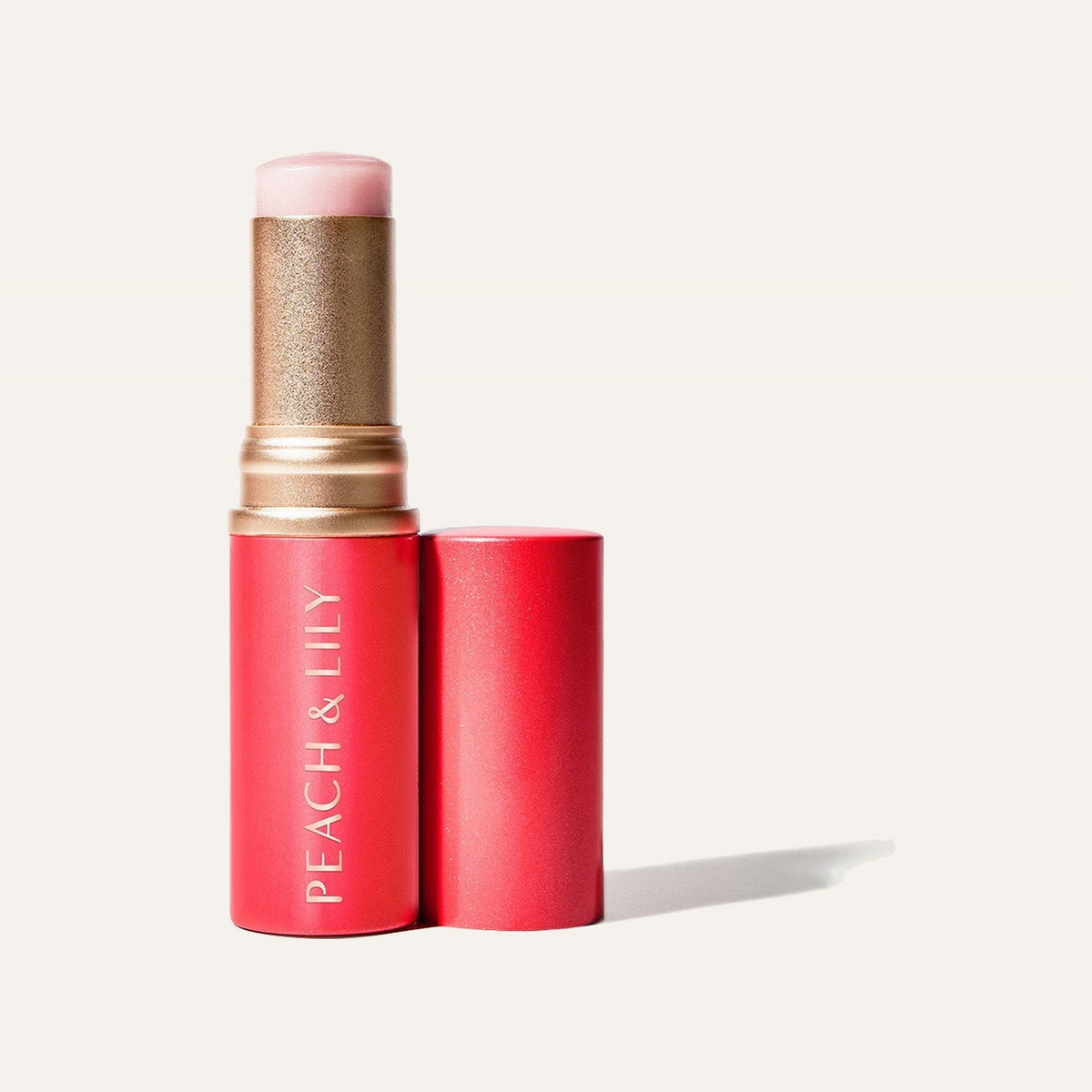 Peach & Lily Glass Skin Luminizing Stick - czerwony sztyft ze złotym elementem i osobna nakrętka | Ellemania